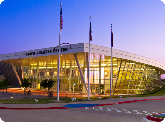 Curtis Culwell Center at dusk with lights on inside the facility